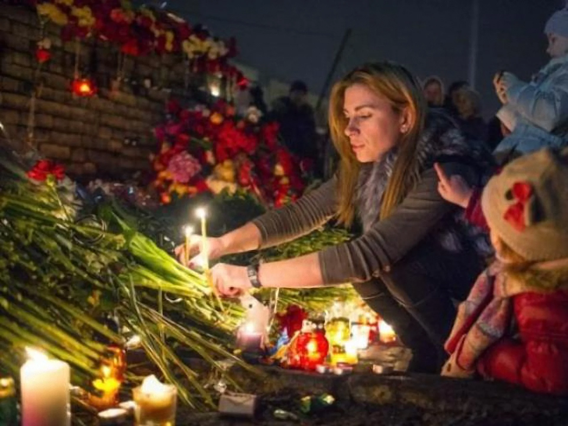 Молода жінка з дитиною вшановують пам'ять героїв