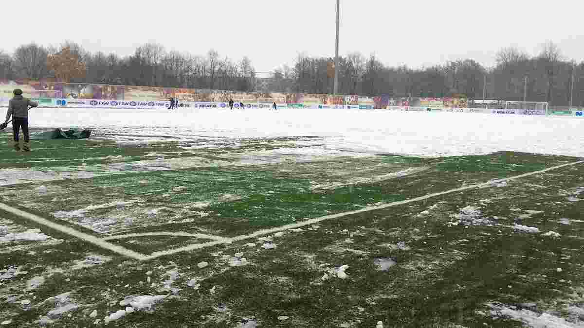 Как игроки команды Калитвинцева чистят поле от снега перед матчем с "Тосно" Милевского