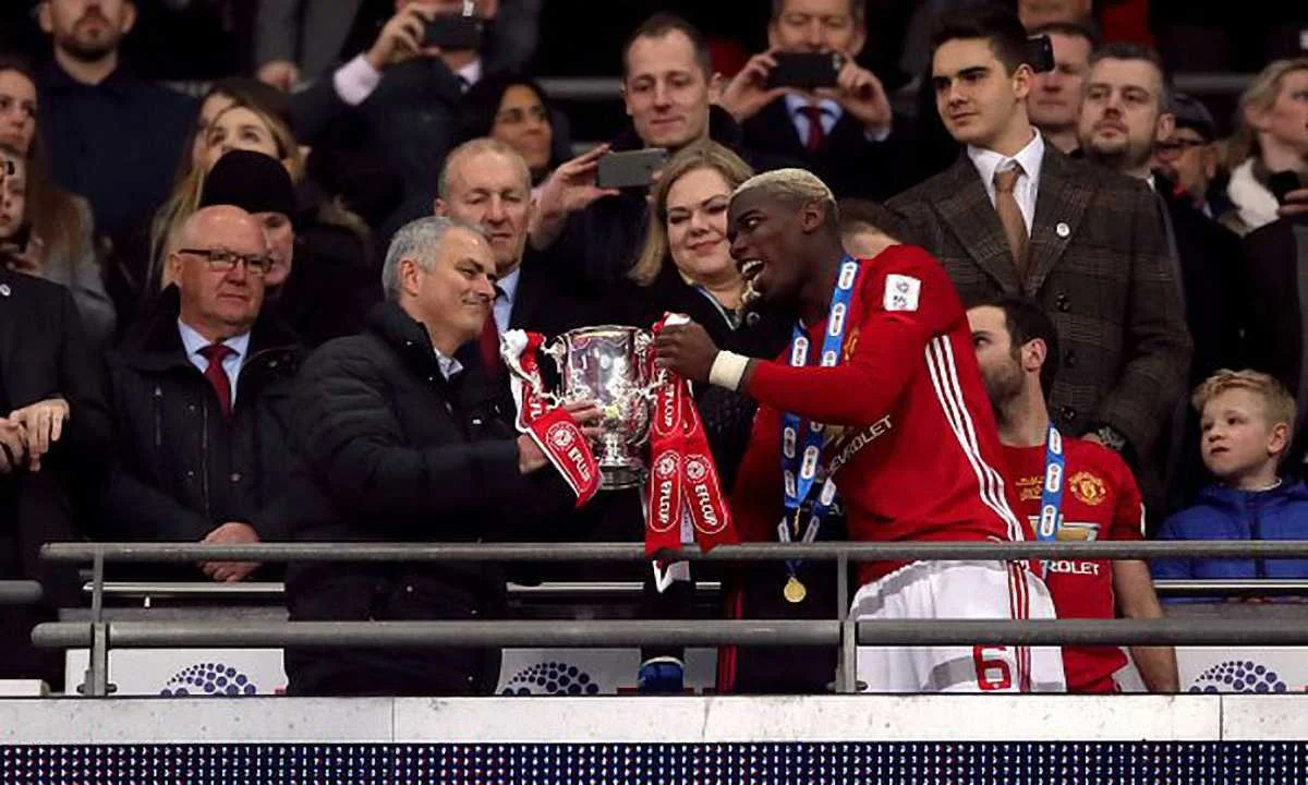 Моуринью принимает трофей из рук Погба