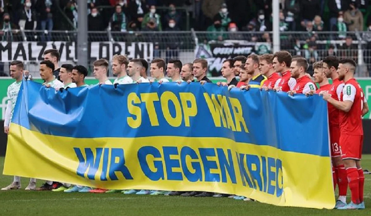 Футболисты на матче Бундеслиги с плакатом против войны в Украине / Getty Images